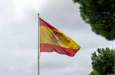 trees, mostly cloudy, hooks, sky, yellow, spanish, blue, red, national, symbol, country, european, nation, banner, background, patriotic, government, patriotism, fabric, emblem, wave, sign, union, bro