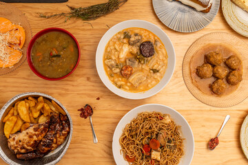 Set of dishes and tapas of Spanish food with fabada, roast chicken, piquillo peppers stuffed with cod, albondigas in sauce, stewed lentils