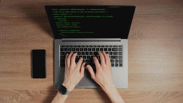 Closeup a man hands are typing commands of a laptop keyboard. A man is writing a program. The developer is coding. Code on the laptop screen. Concept of programming and development web.