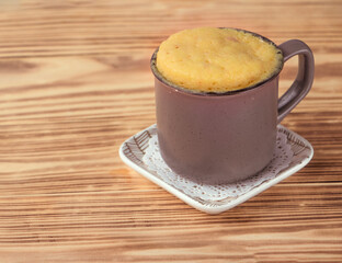 vanilla mugcake is microwaved. Homemade cupcake in a coffee mug. Mini cupcake in a mug. biscuit cake for one. Easy cooking concept, microwave baking. muffin vanilla. Vanilla dessert. food background