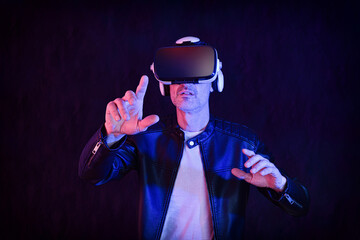 Entertaining man interacting with vr glasses dark isolated background