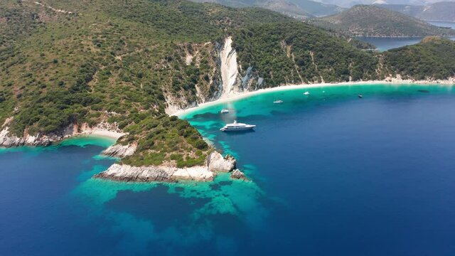 Drone view of Gidaki beach and moored luxury boats on turquoise sea at Ithaca island, Greece