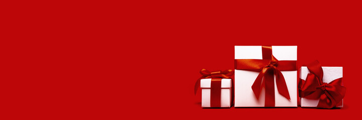 set of tree assorted red and white gift boxes on red background. different size. Merry Christmas and Happy New Year gift shopping and sale concept. St Valentines Day or birthday gift. Minimal edgeless