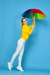 woman with multicolored umbrella in yellow sweater posing rainbow colors