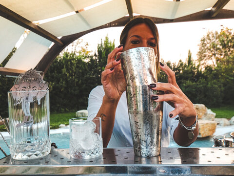 Bar Woman Mixing Cocktails And Drinks Outdoors In A Park Of A Resort Near A Pool