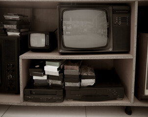 Old video recorder and tv . Vintage Video VHS Player on the shelf. VHS cassette and DVD disc.