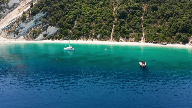 Drone view of Gidaki beach and moored luxury boats on turquoise sea at Ithaca island, Greece