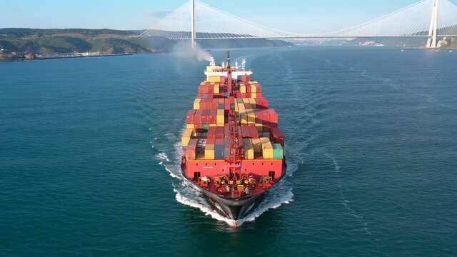 Container Ship underway full speed in Bosphorus Bound.  More water the boat can displace, bigger resulting wakes that trail behind it. Complete deck extends from aft to mooring winches hawser at bow. 