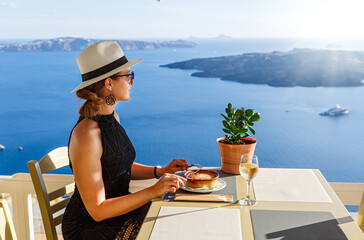 Young woman has dinner in a restaurant overlooking the sea