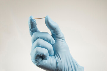 hand in rubber gloves holding a hormonal implant. - obrazy, fototapety, plakaty