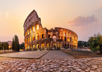 Fototapeta na wymiar Roman Coliseum illuminated at sunrise, summer view without people, Rome, Italy