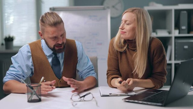 Emotional caucasian man arguing with female colleague during conference at office. Two business partners trying to solve problems at company and find compromise.