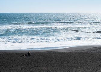 Panoramic view of infiernillo beach in pichilemu with two young women enjoying the sun.