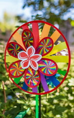 Purchased color toy spinner close-up on the background of greenery and sky in summer