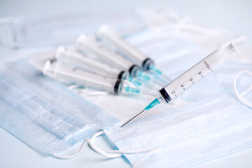 A medical syringe stuck into the table. Disposable syringes and masks. Consumables for injections...