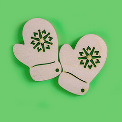 The above view on the handmade wooden gloves on the green background, minimalism New Year or Christmas concept.