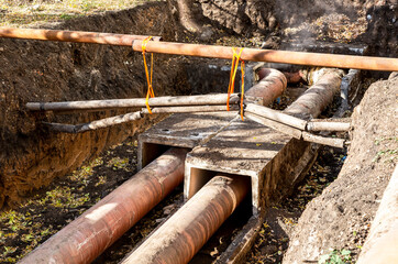 Construction works on large iron pipes at a depth of excavated trench