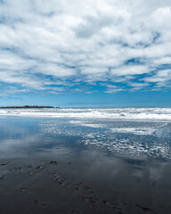 Pichilemu's Infiernillo beach with its black sand on a cloudy day.
