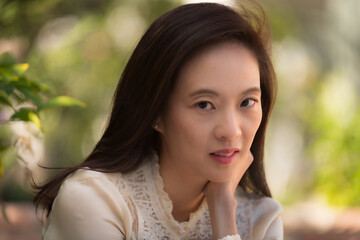 Fashionable woman dressed in delicate pastels wanders a garden in Los Angeles .