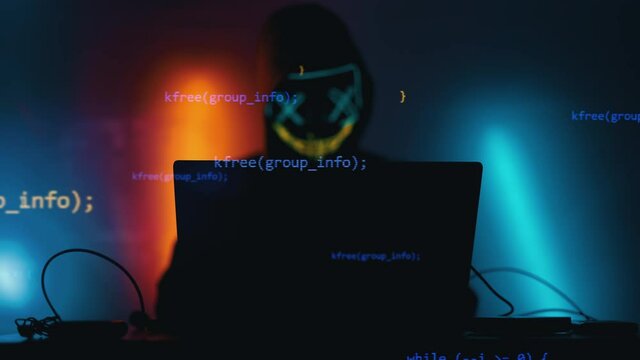 Hacker is working on laptop at night. Hands are typing a virus code at keyboard or hacking website. Concept of bitcoin cryptocurrency and wallet hack. Software coder or blockchain developer