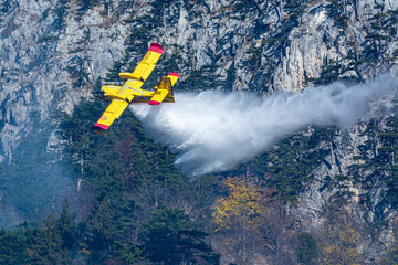 An italien Canadair plane drops water during a forest fire in Hirschwang, Austria