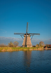 Naklejka premium Ancient windmill on the edge of the canal at Kinderdijk, Netherlands
