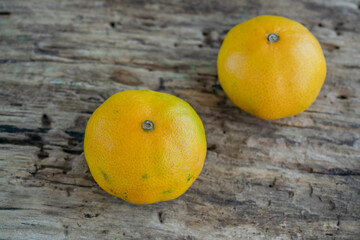 two ripe and fresh tangerine fruits on the wooden table