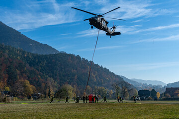 Fototapeta na wymiar Firefighters fill a water Bucket of an Austrian Armed Forces S-70 
