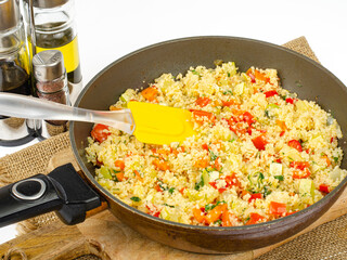Couscous with vegetables in frying pan. Moroccan cuisine dish. Studio Photo