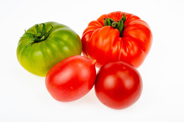 Colored tomatoes of different varieties on white background. Studio Photo