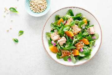 Christmas salmon orange salad with pine nuts, red onion and corn salad lettuce