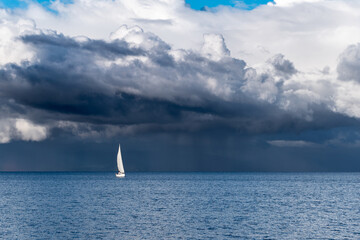 Panoramic view of a sailboat with a background full of storm clouds on lake llanquihue in...