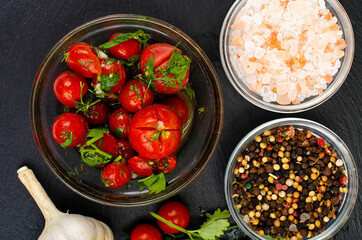 Pickled tomatoes with herbs and garlic. Studio Photo.