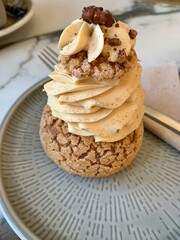 sugar puffs on a plate, puffs filled with creams, pistachio cream and cinnamon cream, two cookies on plates and a cup, fresh sweets and biscuits