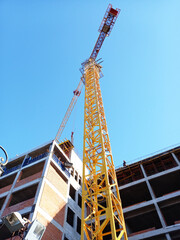 Naklejka premium Construction of a large building. Tower crane at a construction site.