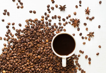 a cup of aromatic coffee on a white background and scattered coffee grains and star anise. good morning . kind of sveru. flat lay. place for text. coffee time.
