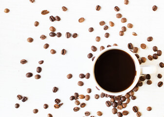 cup of aromatic coffee on a white background and scattered coffee grains. good morning . kind of sveru. flat lay. place for text. coffee time.

