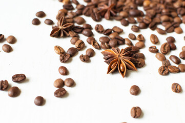 scattered coffee beans and star anise on a white background. kind of sveru. flat lay. space for inspirational text. coffee time.
