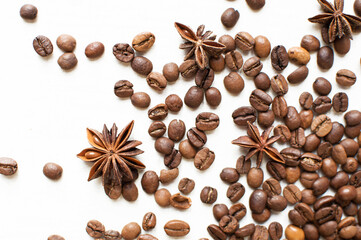 scattered coffee beans and star anise on a white background. kind of sveru. flat lay. space for inspirational text. coffee time.
