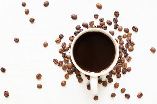 cup of aromatic coffee on a white background and scattered coffee grains. good morning . kind of sveru. flat lay. place for text. coffee time.
