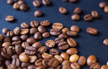 roasted aromatic coffee beans on a dark background. coffee background. flat lay with place for text. view from above.
