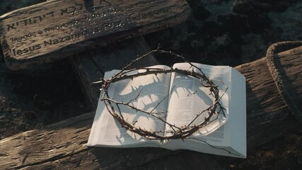Bible and crown of thorns on cross