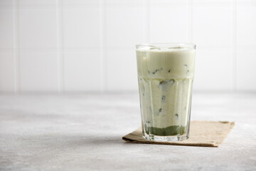 iced matcha green tea with milk and ice on a gray table