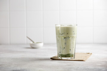iced matcha green tea with milk and ice on a gray table