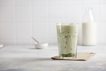 iced matcha green tea with milk and ice on a gray table