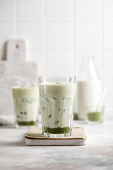 iced matcha green tea with milk and ice on a gray table