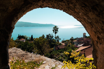 Lovely landscape with a palm tree, house roofs and sea in Herceg Novi, Montenegro