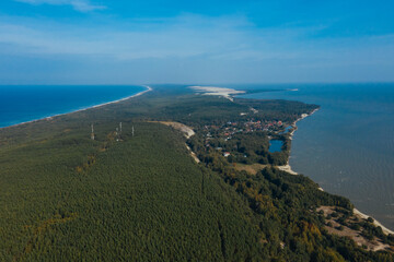 A view from a height of a narrow and long sandy saber-shaped strip of land separating the Curonian Lagoon from the Baltic Sea. Gray sand dunes of the Curonian Spit.
