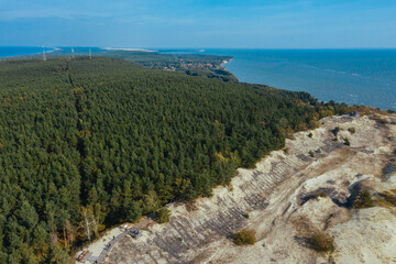 A view from a height of a narrow and long sandy saber-shaped strip of land separating the Curonian Lagoon from the Baltic Sea. Gray sand dunes of the Curonian Spit.