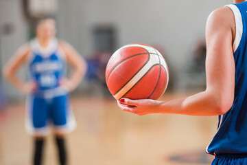 Woman keeps the ball during basketball match.